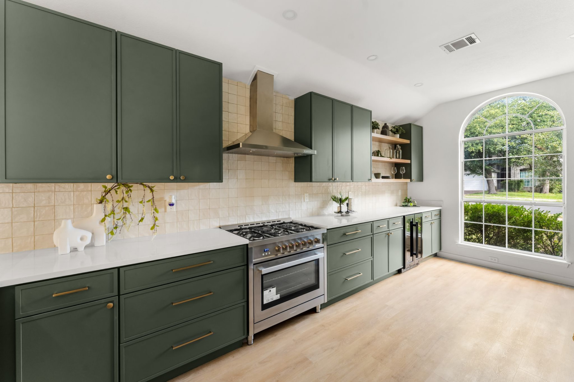 Gent Drive full remodel: modern kitchen with dark green cabinetry and a large arched window